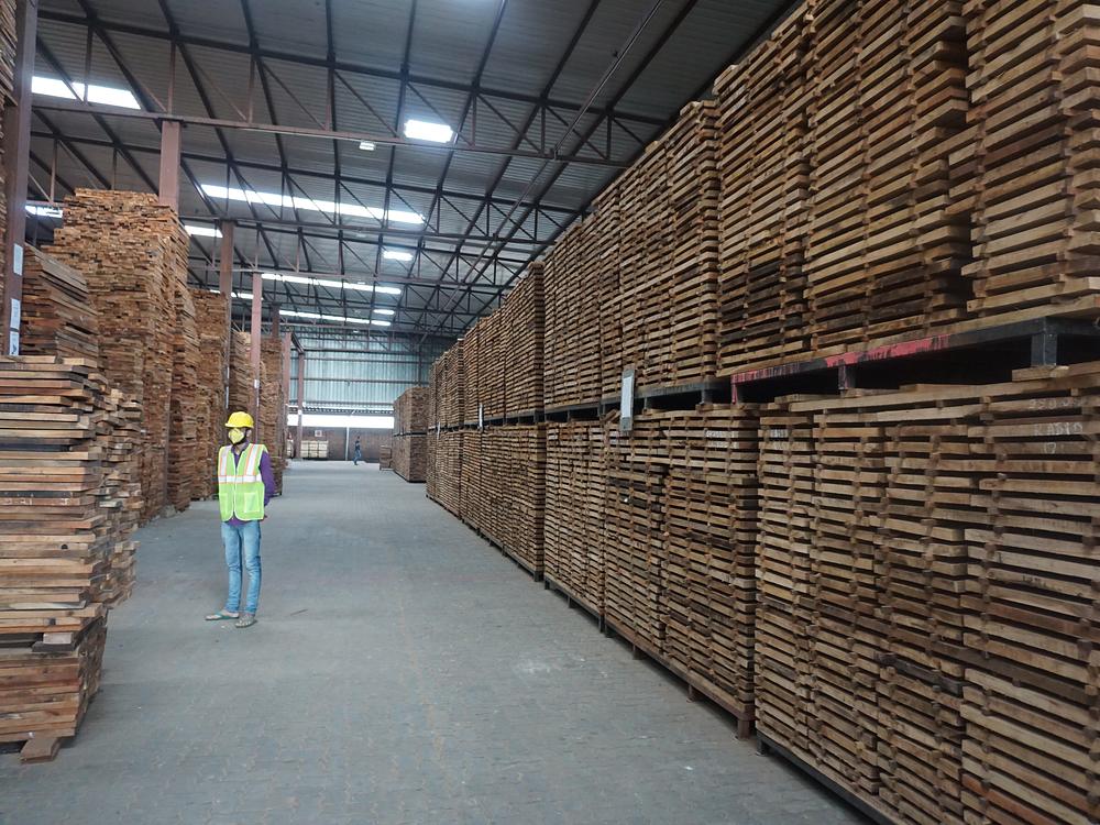Aisle between stacked sawn boards in a covered timber store