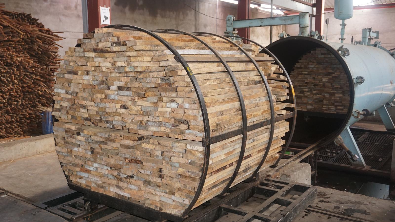 A cylindrical charge of sawn timber loaded onto a bogie ready to enter the treatment vessel